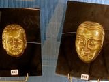 deux masques dorés exposés dans une vitrine