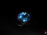 a close up of a blue diamond on a black surface
