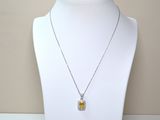 necklace with a yellow and white pendant on a white mannequin