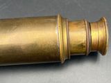 an old brass telescope is sitting on a table with a black background