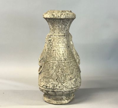 un vase en pierre posé sur une surface blanche