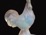 a glass sculpture of a rooster on a wooden table