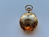 a gold pocket watch with a picture of a man on it