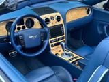the interior of a blue sports car with a wooden dash board