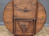 an old wooden table with a wooden top and a metal stand