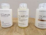 three bottles of olaplex hair care sitting on a table