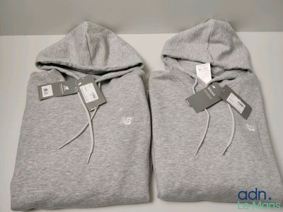deux sweats à capuche gris posés l'un à côté de l'autre sur une table blanche