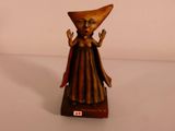 une petite statue représentant une femme coiffée d'un chapeau