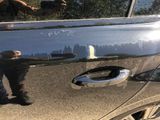 a man standing next to a car with a banana on the door handle