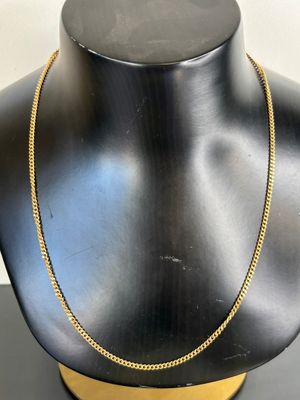 a black mannequin with a gold chain on it
