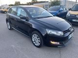 the black volkswagen polo is parked in a parking lot with other cars