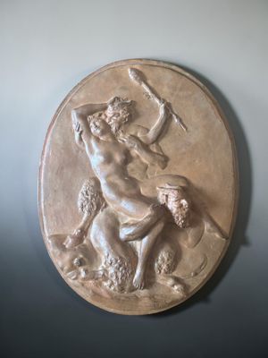 a bronze plaque of a man on a horse with a spear