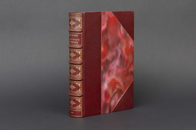 un vieux livre à la couverture rouge posé sur une table