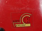 a close up of a red skateboard with a sticker on it