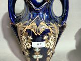 a blue vase with a gold decoration on it