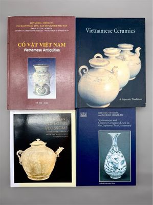 trois livres posés sur une table, sur laquelle se trouvent des vases