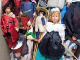 a lot of dolls in a cardboard box on the floor