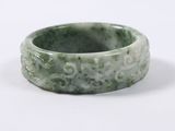 a picture of a green jade ring on a white surface