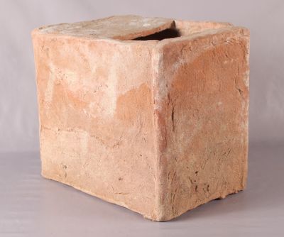 une boîte en pierre avec un couvercle, posée sur une table