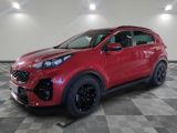 une voiture rouge est garée sur le sol en damier d'un garage