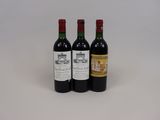 trois bouteilles de vin rouge sont posées sur une surface blanche