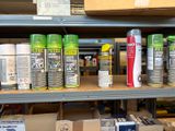 many cans of spray paint on a shelf in a store