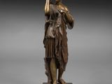 une statue en bronze représentant une femme tenant un oiseau, posée sur un socle en marbre
