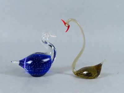 two glass birds sitting next to each other on a table