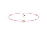 un bracelet en cordon rose orné d'un pendentif en forme de cœur et d'un diamant