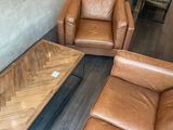 deux canapés en cuir marron et une table basse dans un salon