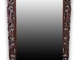 un grand miroir avec un cadre en bois orné de motifs sculptés