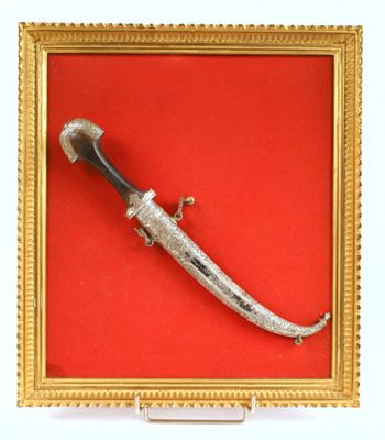 tableau représentant un poignard, dans un cadre doré sur fond rouge