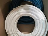 two white and blue hoses in a cardboard box on top of each other