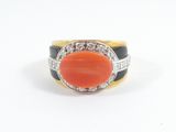 a close up of a ring with an orange stone and diamonds