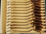 six forks in a case with a gold handle