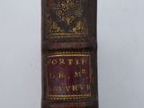 an old book sitting on top of a wooden table next to a white wall