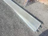 a metal grate laying on the ground next to a chair