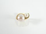 a white pearl and gold ring on a white surface