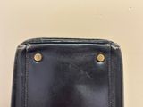 a close up of a black purse on a white surface