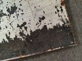 a piece of metal that has been rusted and is sitting on the ground