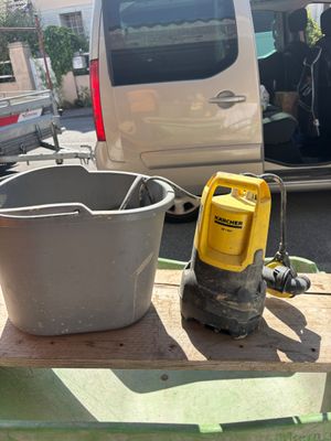un seau d'eau posé sur une table à côté d'un autre seau d'eau