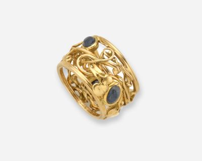 gros plan d'une bague en or avec une pierre noire