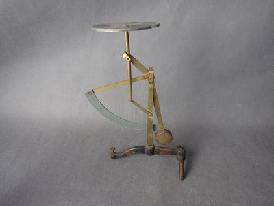 une table en métal avec un plateau en verre sur fond gris