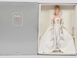 La poupée Barbie est dans une boîte, vêtue d'une robe blanche.