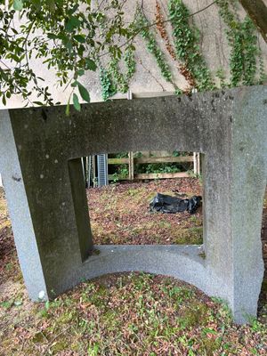 a concrete bench with a mirror on it in the grass