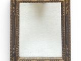 un miroir ancien dans un cadre doré, avec un fond blanc