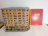 a model of a building on a table next to a book