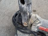 a sander that is sitting on the ground next to a bag