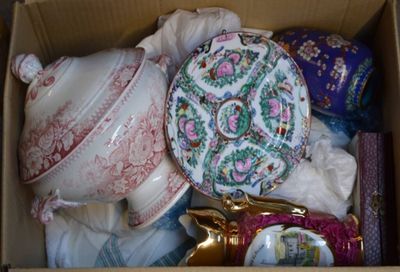 une boîte remplie d'objets divers, notamment une théière, un pot à thé et une paire de ciseaux