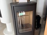 a black stove sitting in a room with a sign on it